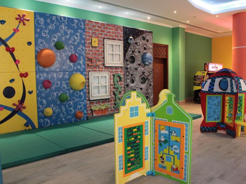 Bunte Kinderspieleecke mit Kletterwand, Spielhaus und interaktivem Lernspielzeug aus Kunststoff.
