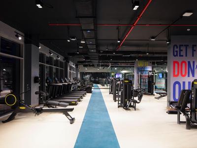 Gimnasio moderno y luminoso con equipo en área de reservas de hotel.