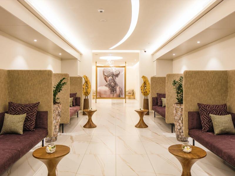 Moderne, lichte wachtruimte met comfortabele zithoeken en decoratieve tafels in hotelomgeving.