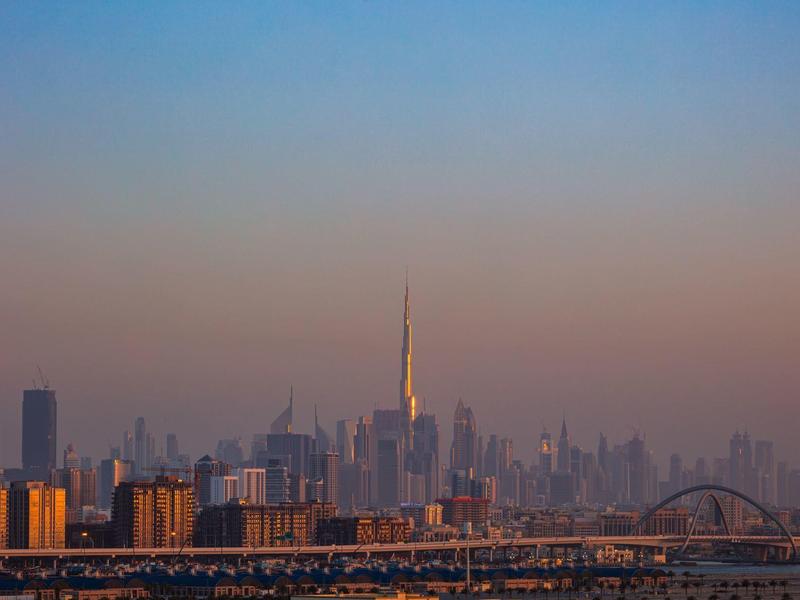Stedelijke skyline bij zonsondergang met hoge gebouwen en heldere lucht.