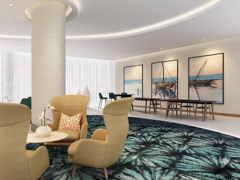 Moderne hotel lounge met comfortabele fauteuils en grote landschapsfoto's aan de muur.