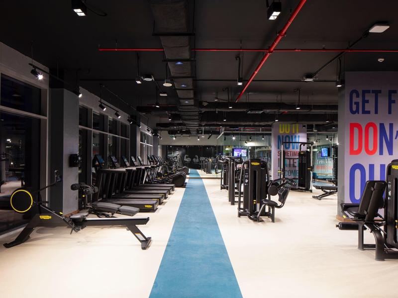 Moderne fitnessruimte met apparatuur en blauwe loopbaan in een hotel