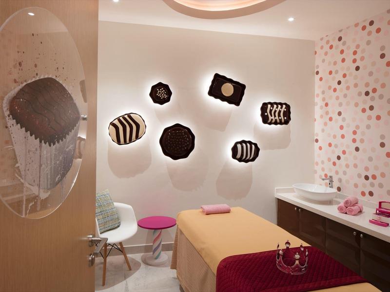 Gezellige wellnessruimte met massagetafel, decoratieve wandkunst en gestippeld behang.