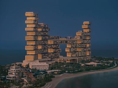 Großes, modernes Gebäude mit rechteckigen, gestapelten Blöcken an einer Küste bei Dämmerung.