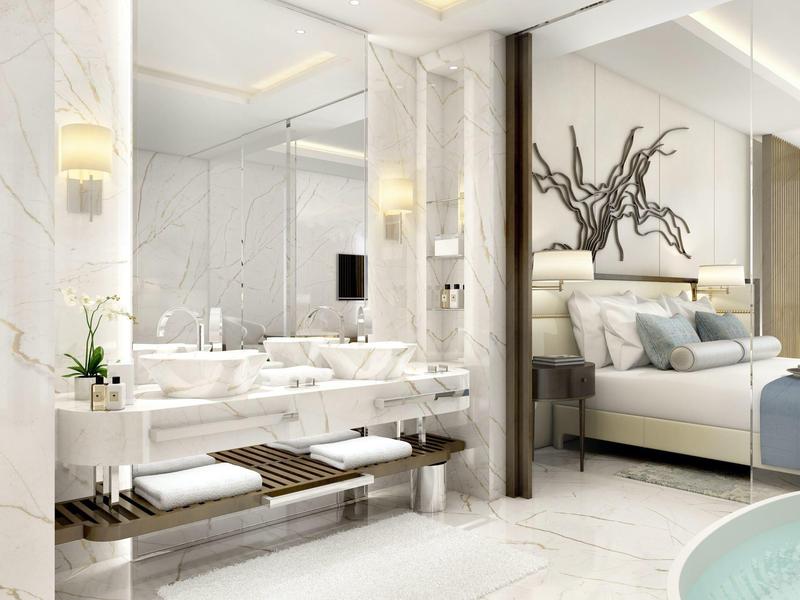 Modernes Badezimmer mit Marmorwänden, Doppelwaschbecken und Blick auf ein Schlafzimmer.