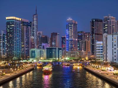 Night cityscape with illuminated river and modern skyscrapers