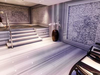 Modern spa area with illuminated stairs, blue-gray walls, and decorative plant vases.