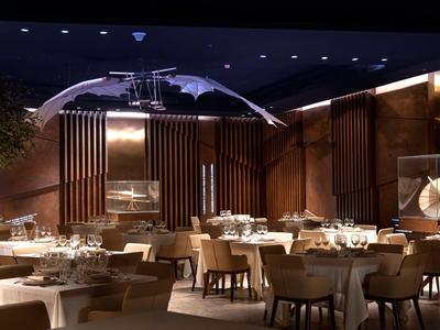 Restaurant élégant avec décoration en bois moderne, tables dressées et éclairage chaleureux.