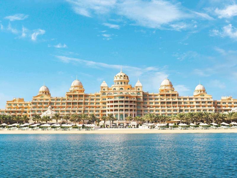 Luxuriöse Hotelanlage mit mehreren Kuppeln am Strand, vor blauem Meer und Himmel.