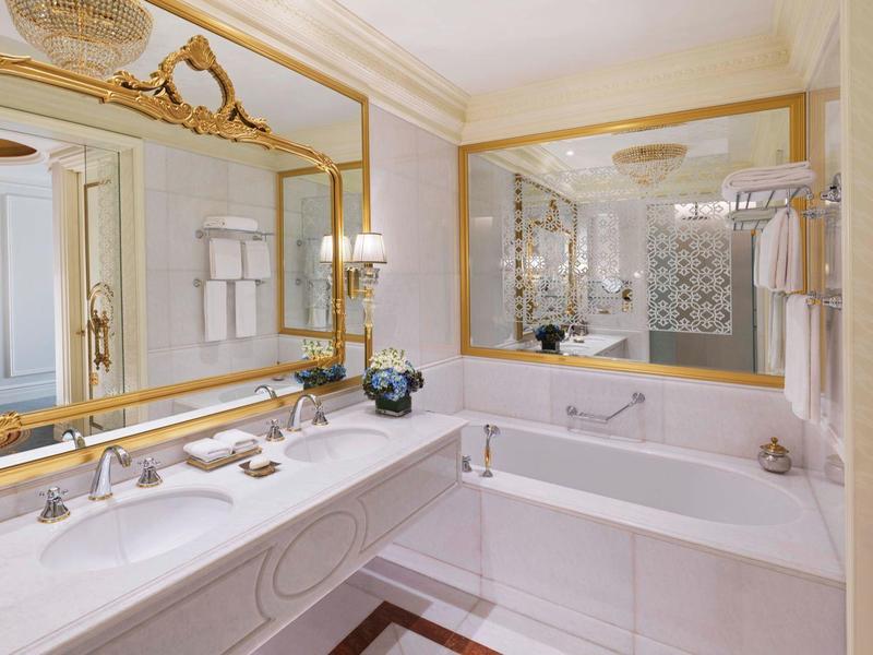 Elegantes Badezimmer mit großem Spiegel, Marmorwaschtisch und integrierter Badewanne.