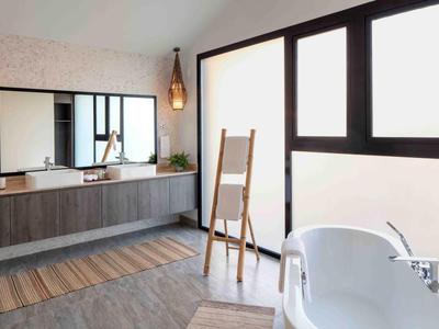 Baño moderno con bañera independiente, gran espejo y luz natural.