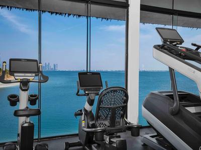 Gym with modern equipment and sea view through large windows