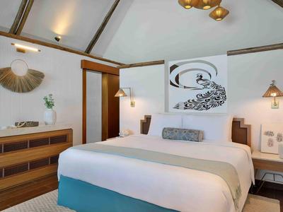 Habitación de hotel acogedora con cama grande, muebles de madera y decoración en la pared.