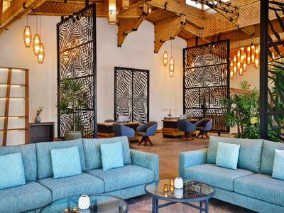 Modern hotel lobby area with blue sofas and decorative wooden elements.