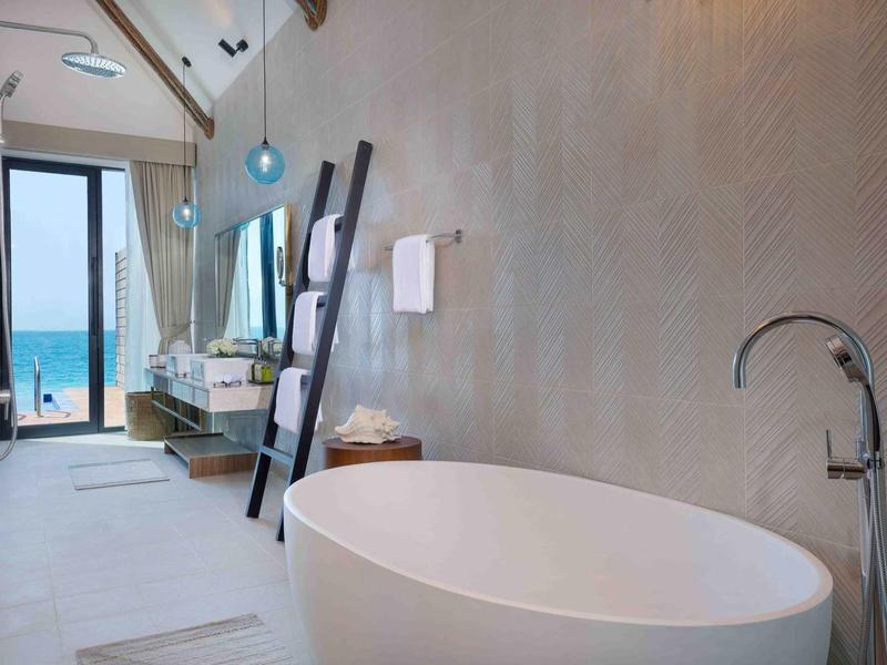 Gimnasio con equipos modernos y vista panorámica al mar en un día despejado.