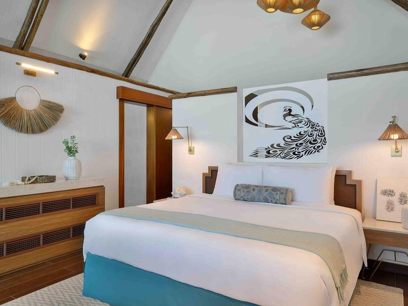 Habitación de hotel acogedora con cama grande, muebles de madera y decoración en la pared.