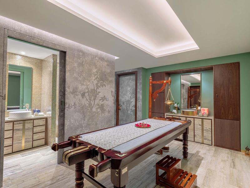 Moderner billardtisch im Raum mit grünen Wänden, Holzschränken und indirekter Deckenbeleuchtung.