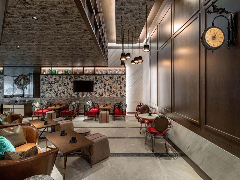 Modernes Café mit gemusterten Wänden, braunen Möbeln und warmem Licht, gemütliche Sitzbereiche.