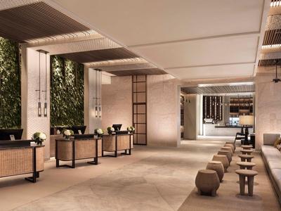 Moderner Hotel-Lobby-Bereich mit Pflanzenwand und gemütlichen Sitzgelegenheiten in warmen Tönen.