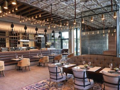 Modernes Restaurant mit gemütlichen Tischen, Stühlen und indirekter Beleuchtung.