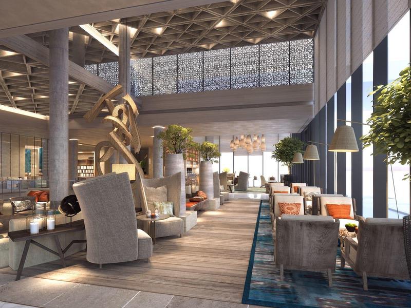 Modernes Loft mit hohen Fenstern, Holzboden, grauen Sesseln und dekorativen Pflanzen.