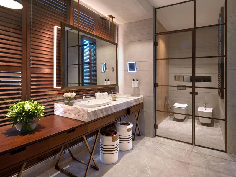 Moderner Badezimmerspiegel mit Holzdetails, Glasdusche und stilvollen Sanitäranlagen.