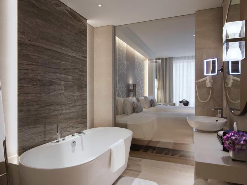 Modern bathroom with freestanding bathtub and view into the bedroom.