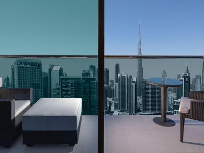 Balkon z miejscami do siedzenia i stołem z widokiem na miasto z drapaczami chmur.