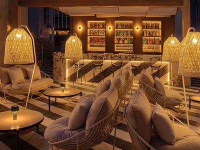 Gemütliche Lounge mit bequemen Sesseln, warmem Licht und dekorativen Lampenschirmen.