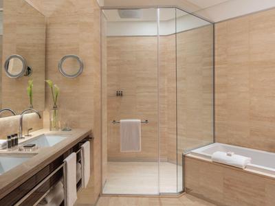 Modernes Badezimmer mit Glas-Dusche, weißer Badewanne und Waschtisch mit großem Spiegel.