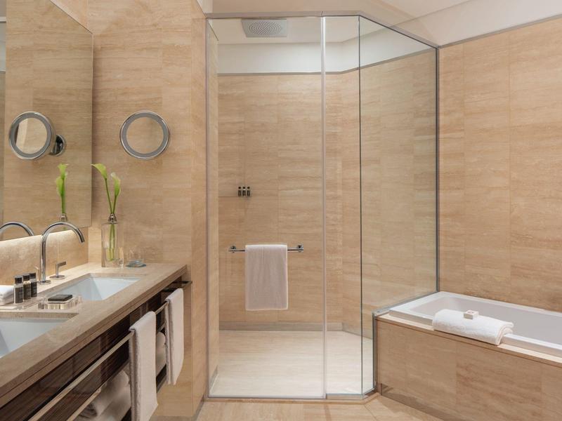 Modernes Badezimmer mit Glas-Dusche, weißer Badewanne und Waschtisch mit großem Spiegel.