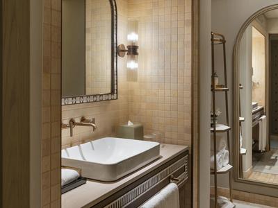 Modern bathroom with rectangular sink, wall mirror, and beige tiles.