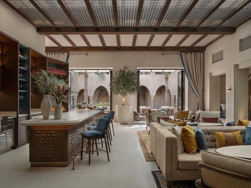 Elegant hotel lounge area with comfortable sofas, chairs, and view of an inner courtyard.