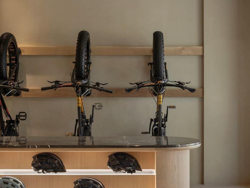 Modern bike rental with illuminated wooden counter and bike helmets.