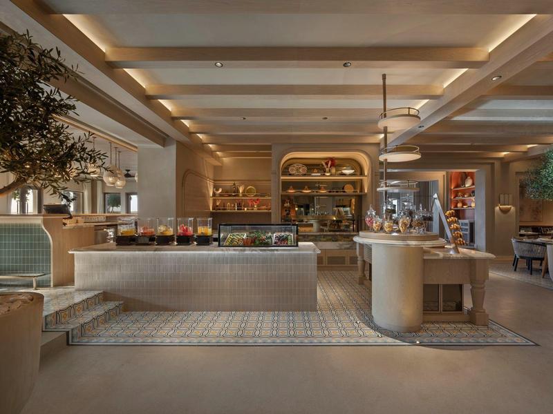 Elegant hotel lobby area with seating, rugs, and warm lighting.