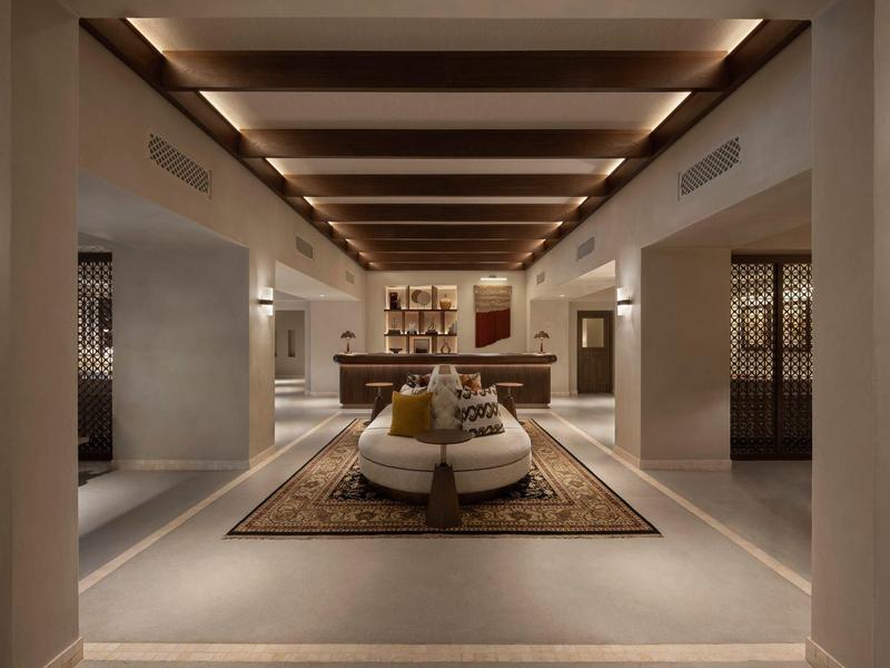Modern hotel lounge area with central seating and warm ceiling lighting