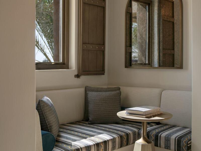 Cozy nook with padded seat cushions, wooden table, and wall mirror.