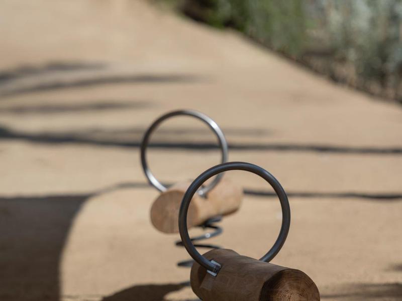 Close-up of several metal springs on sandy ground outdoors.