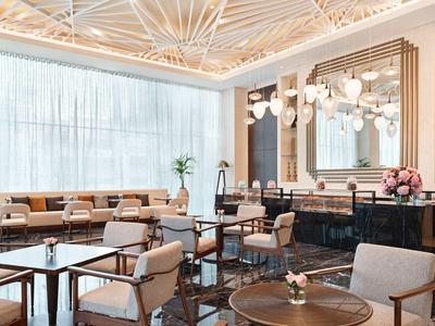 Elegancka sala restauracyjna w hotelu z nowoczesnymi meblami i dużymi oknami.