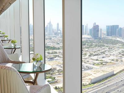 Widok z pokoju hotelowego z wygodnymi fotelami i stolikami na miasto i autostrady.