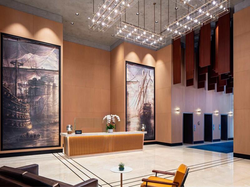 Modern hotel lobby with a large reception, stylish artwork, and comfortable seating.