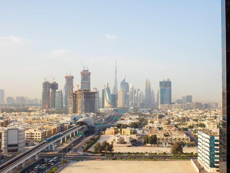View of a large city skyline with skyscrapers and busy street.
