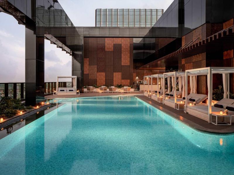 Modern outdoor pool with canopy loungers at a stylish hotel.