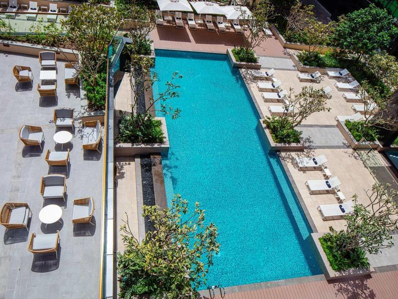 View of a well-maintained hotel pool area with lounge chairs and seating groups.