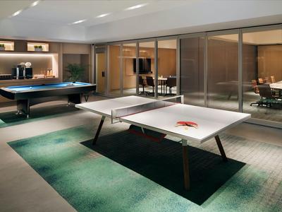 Moderner Freizeitraum mit Billardtisch und Tischtennisplatte in einem Hotel.