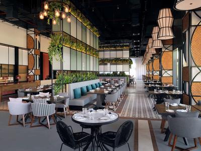 Modernes Restaurant mit großem Gastraum, runden Tischen, grünen Sitzbänken und hängenden Pflanzen.