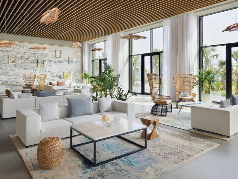 Modernes Wohnzimmer mit großem Fenster, weißen Sofas, Teppich, Pflanzen und Holzdecke.