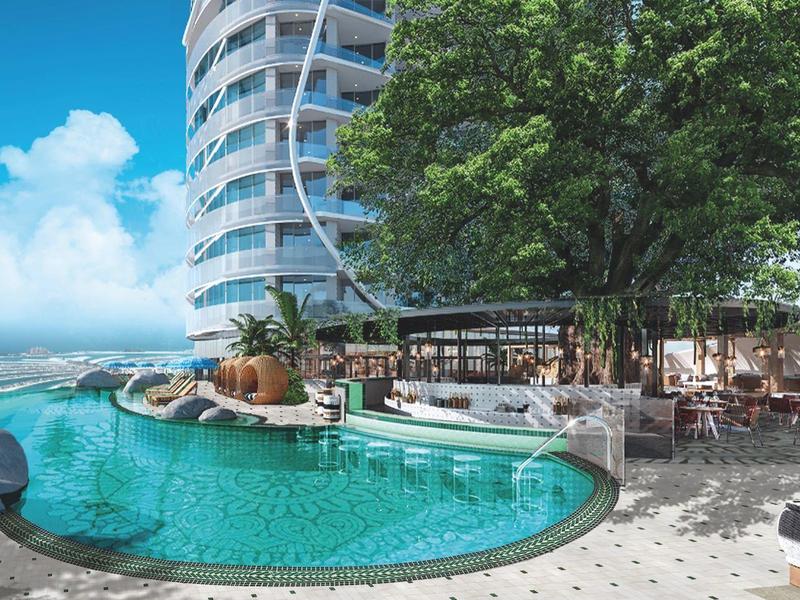 Modern hotel pool with ocean view, surrounded by trees and sun terrace.