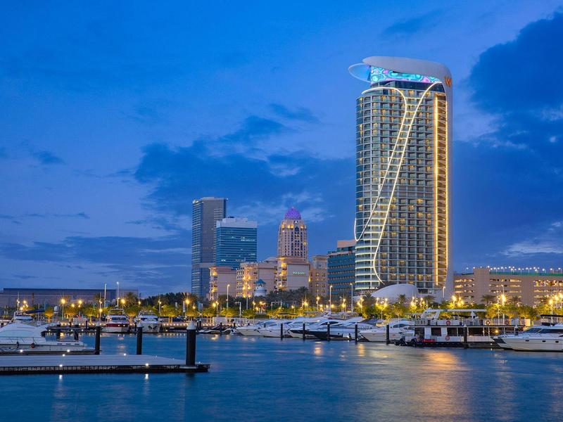 View of illuminated hotels and marina by the water at dusk