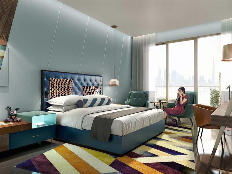 Moderní hotelový pokoj s velkou postelí, barevným kobercem a panoramatickými okny s výhledem.